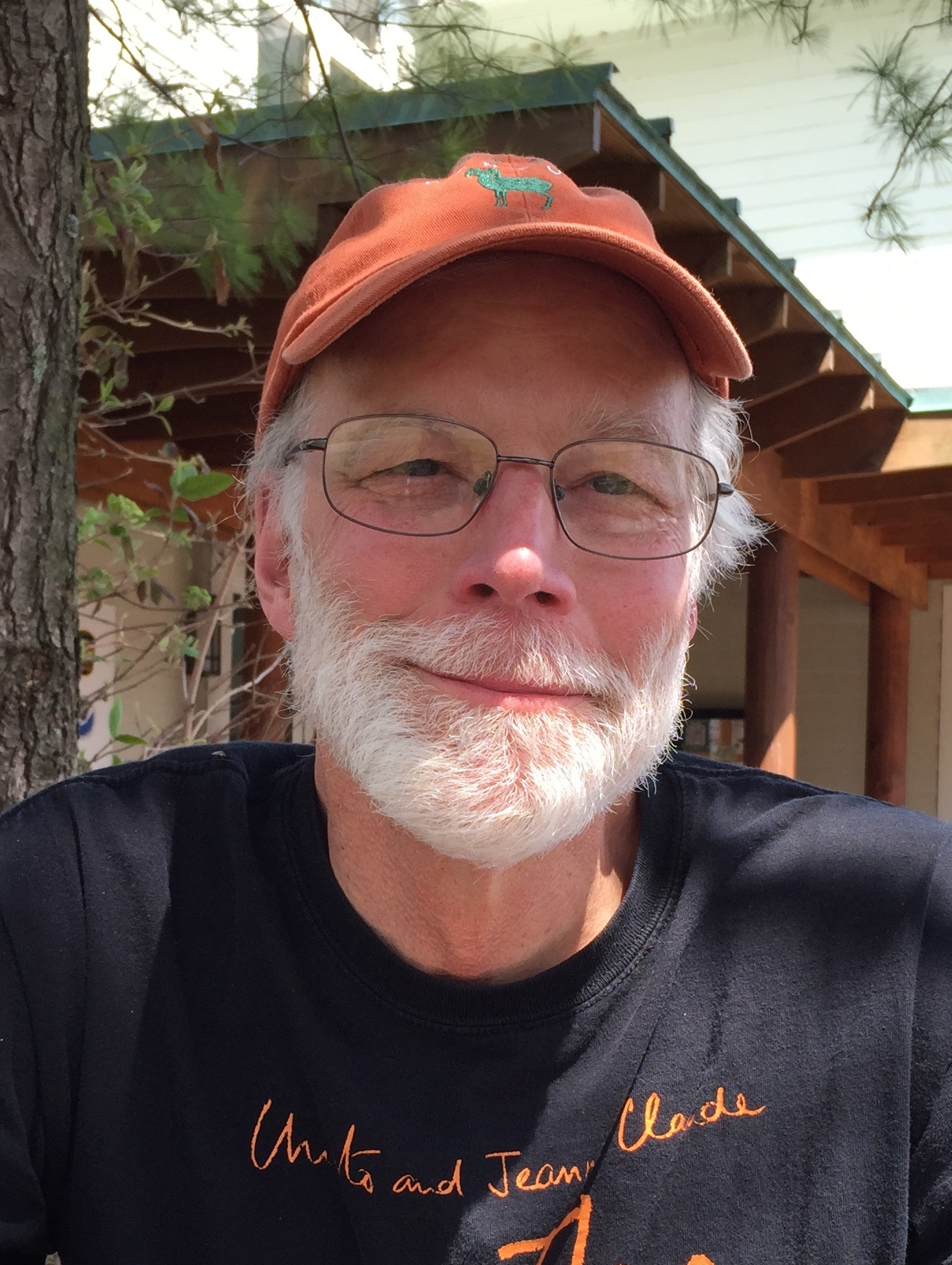 John Barber wearing an orange baseball cap and black shirt with orange writing.